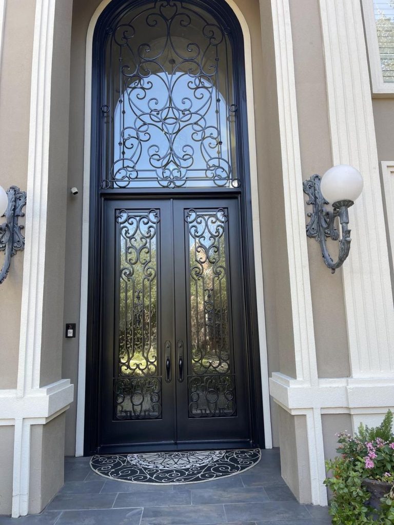 Tall arched iron front door painted black