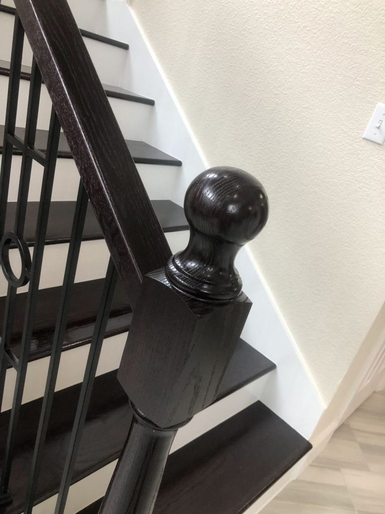 Black stained newel post and handrail on a refinished staircase