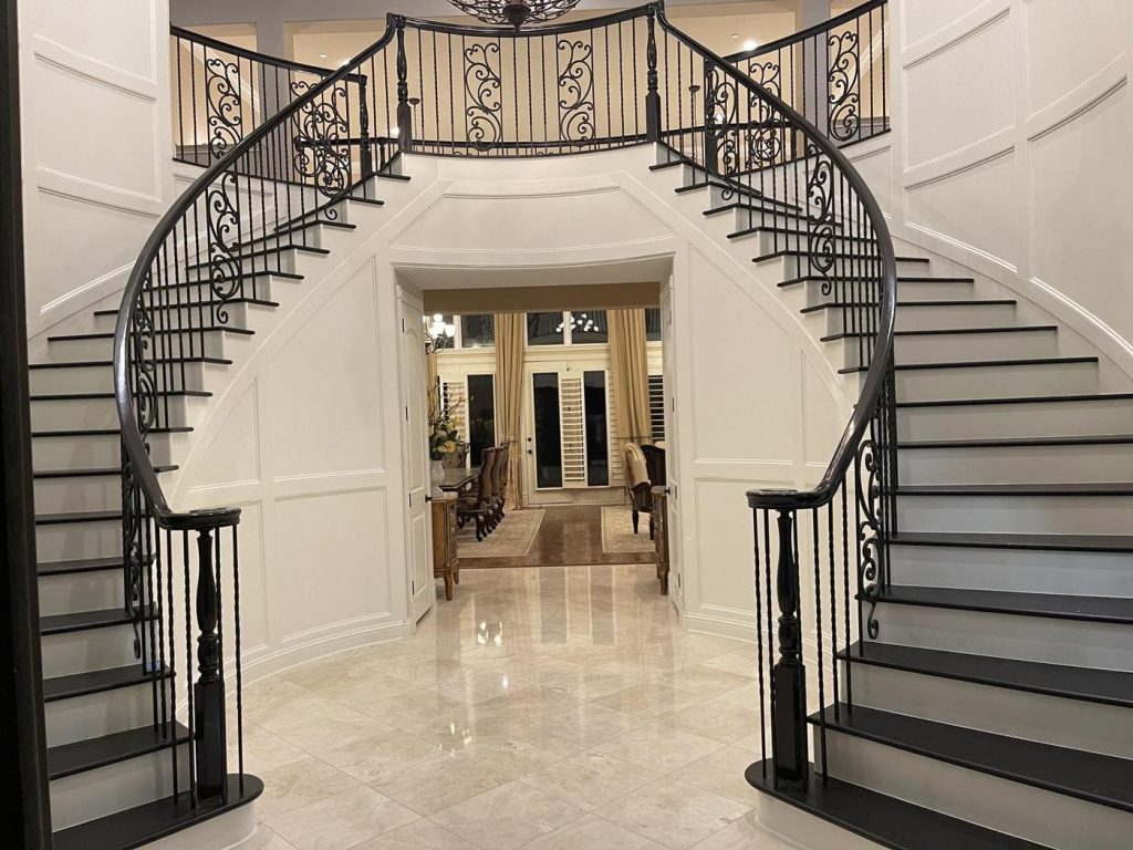 Refinished double curved staircase with dark treads and white risers