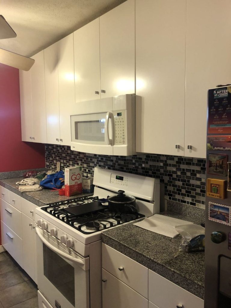 Refinished white kitchen cabinets with a tile backsplash
