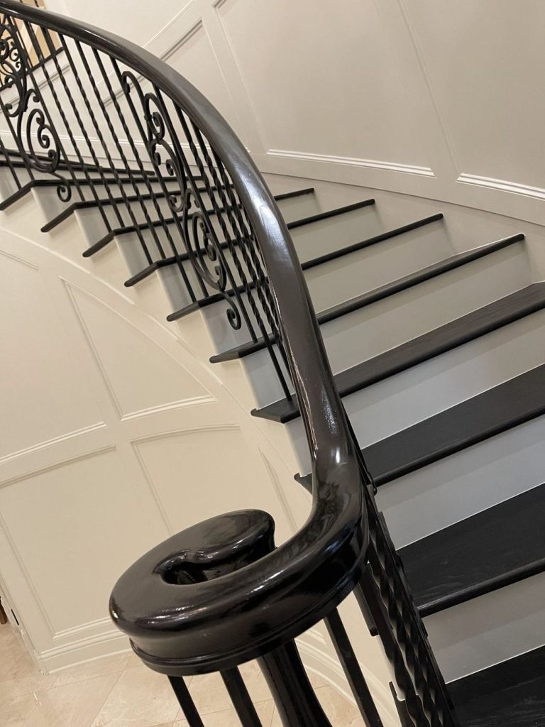Close-up of a stained curved handrail and stair treads