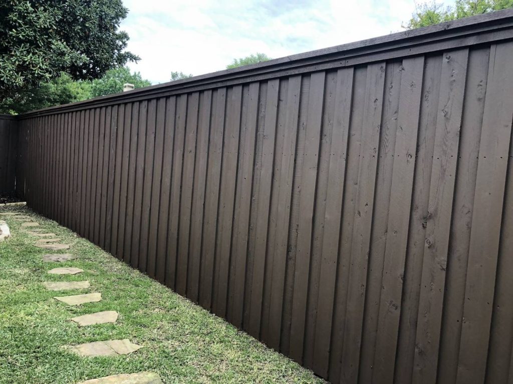 Wood privacy fence after staining in a rich brown