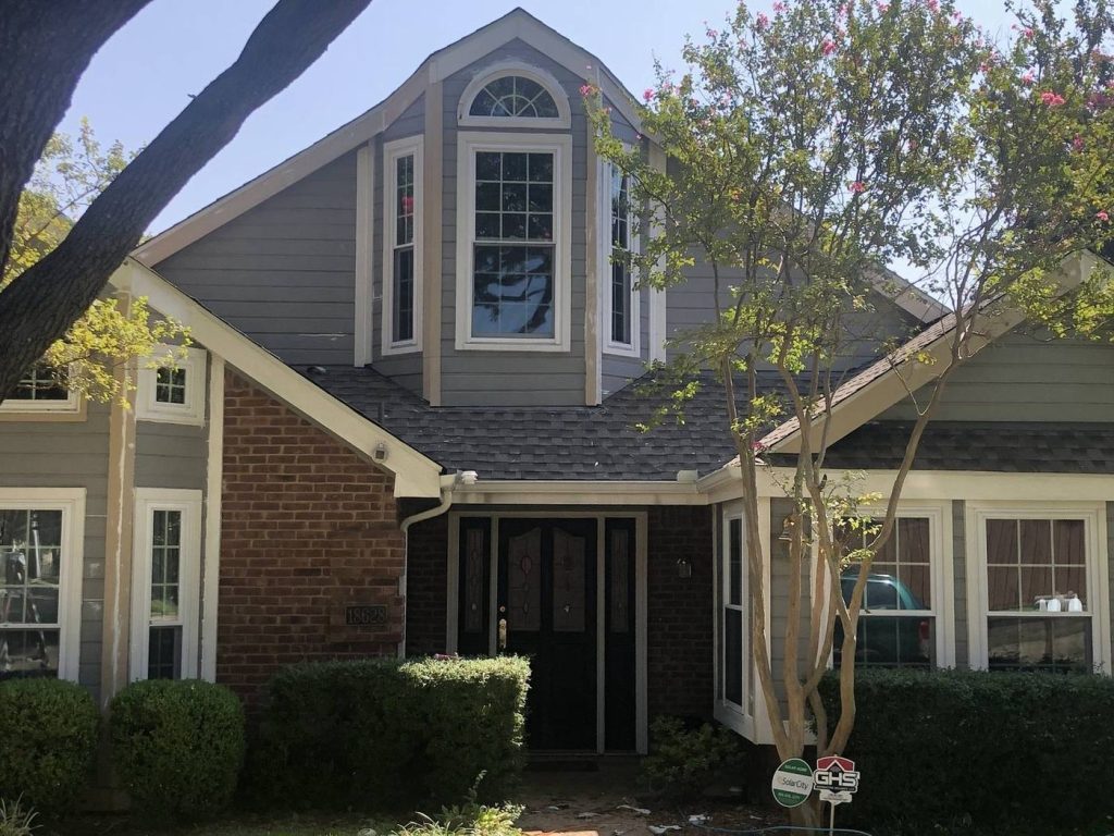 Two-story home with newly painted gray siding and white trim